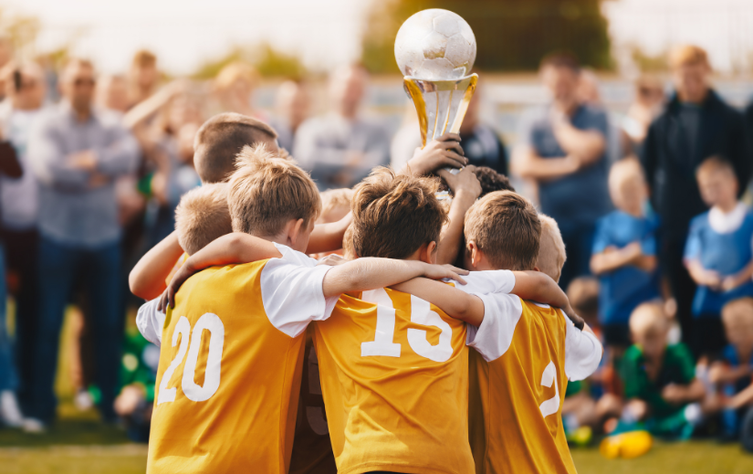 Youth soccer team celebrating with a trophy, symbolizing teamwork and success, ideal for social media video ads.